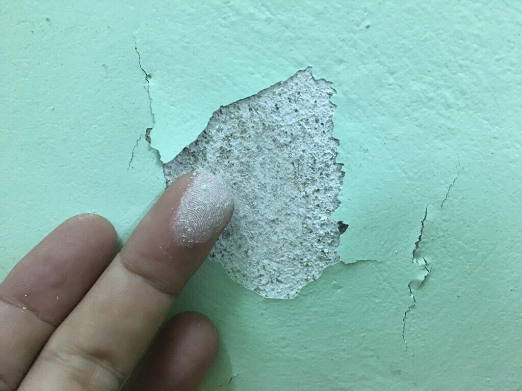 Bề mặt tường bong tróc được làm mịn trước khi thực hiện các bước sơn nhà