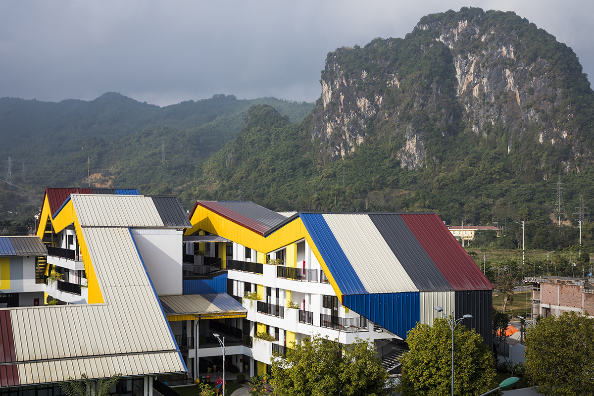 Trường học có mái tôn nhiều màu sắc nổi bật trên nền xanh của núi rừng