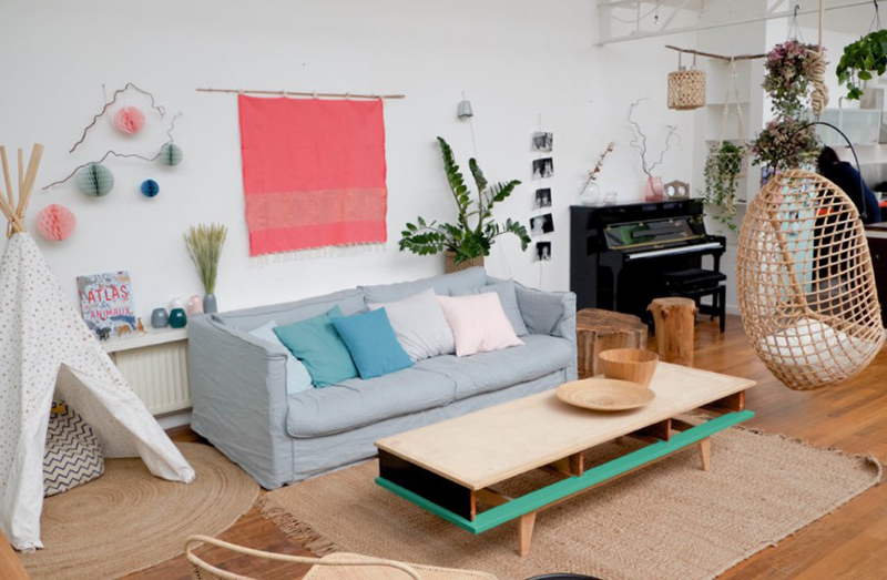 Màu hồng và xanh pastel thêm sức sống cho không gian phòng khách Scandinavia có  tường trắng và sàn gỗ màu nâu trung tính.