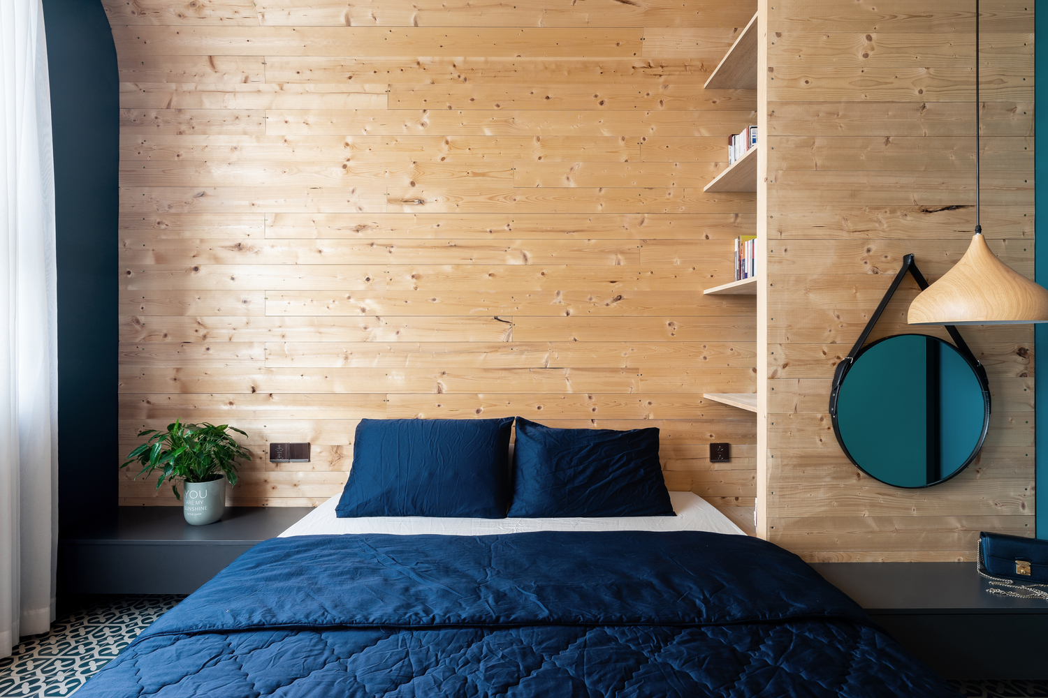 Phòng ngủ thoáng đãng, đầy ánh sáng tự nhiên, hài hòa với vẻ mộc mạc của hệ khung mái vòm bằng gỗ. 