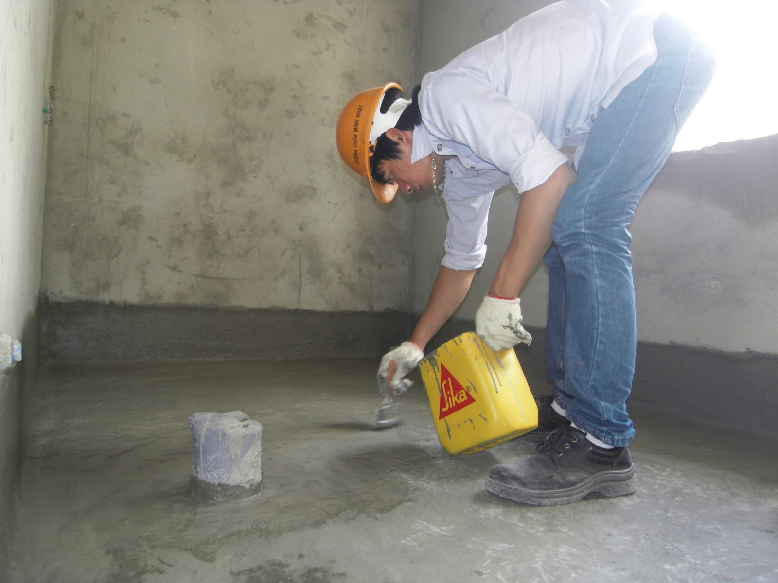 công nhân đang quét dung dịch chống thấm sika lên sàn nhà vệ sinh