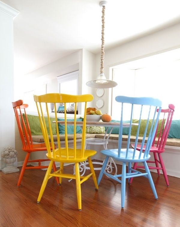những chiếc ghế tựa sơn màu khác nhau đặt quanh bàn tròn