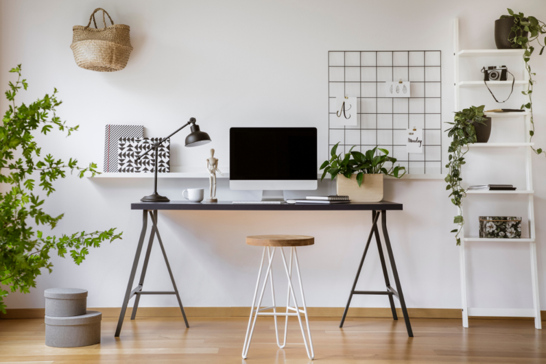 Phòng làm việc tại nhà gồm bàn đơn giản, laptop, đèn, các chậu cây xanh
